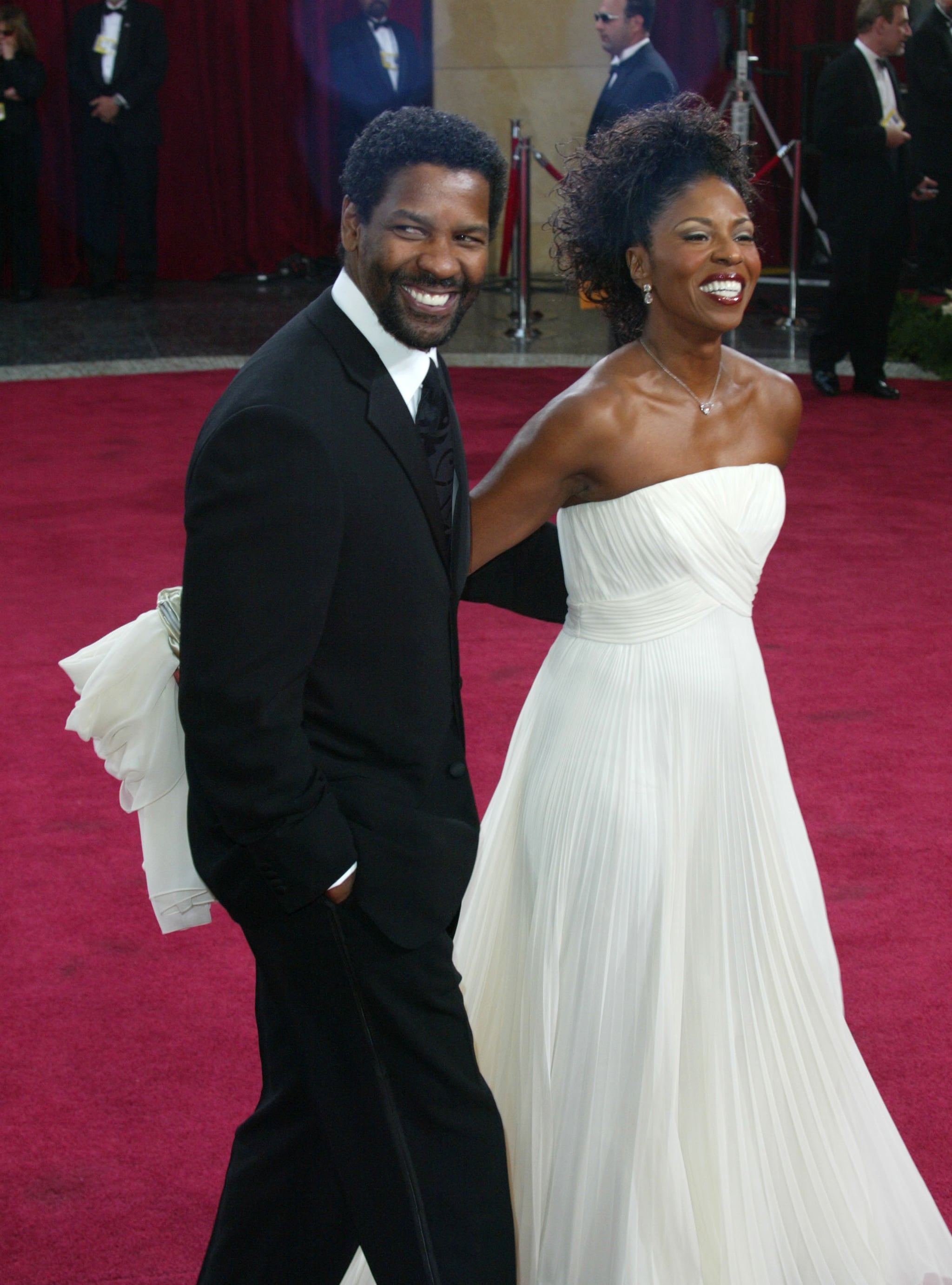 Pauletta Washington and Denzel Washington wearing coat pant and white gown